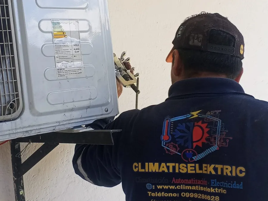 Técnico de Climatiselektric instalando una unidad condensadora RCA en su soporte